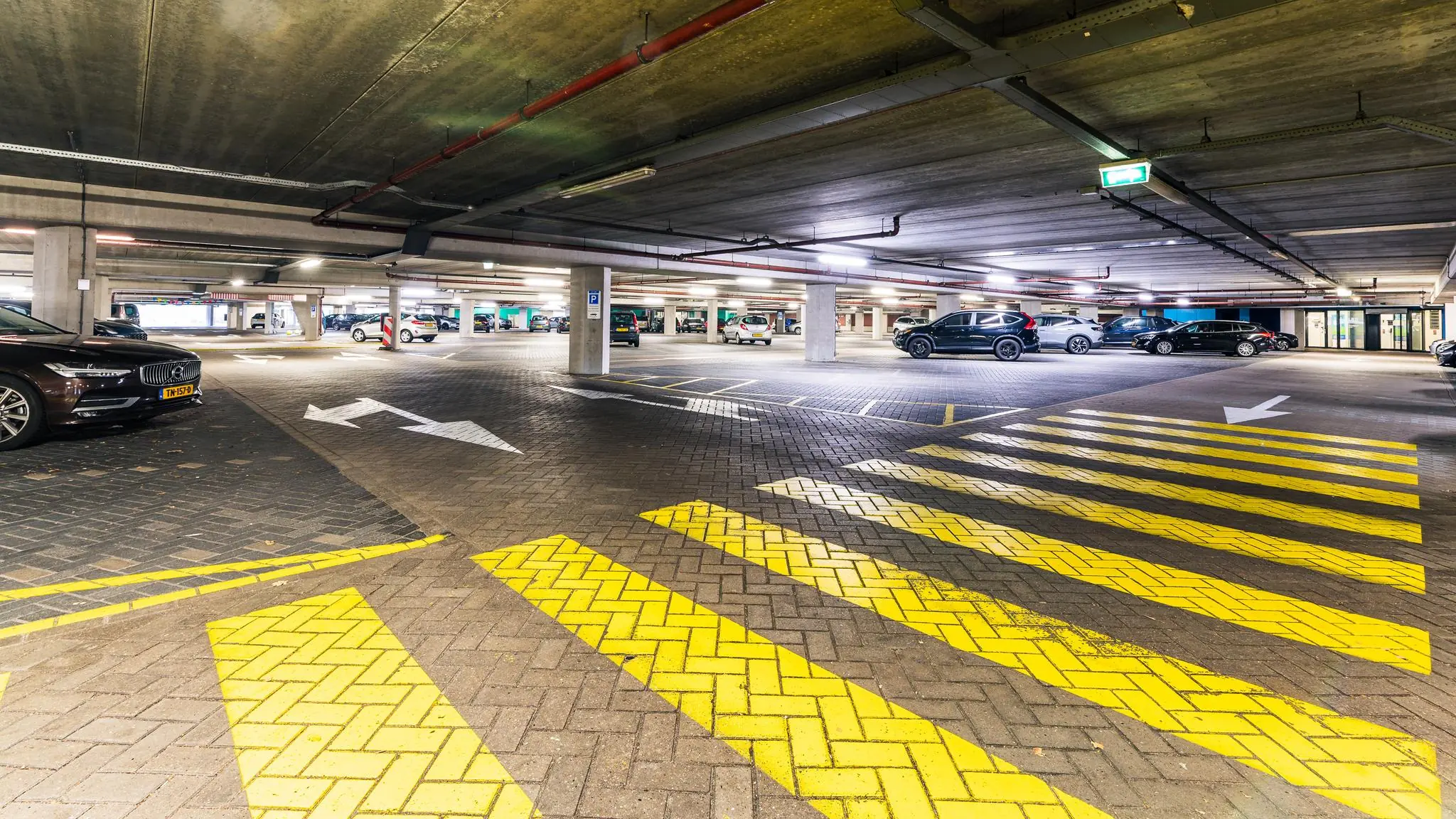 Overdekte parkeergarage aan de George Hintzenweg met geparkeerde auto's en opvallende gele en witte wegmarkeringen.